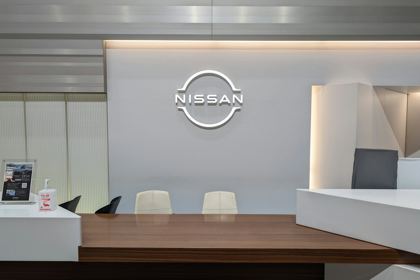 Nissan-Logo über einem Empfangstresen in einem Autohaus.